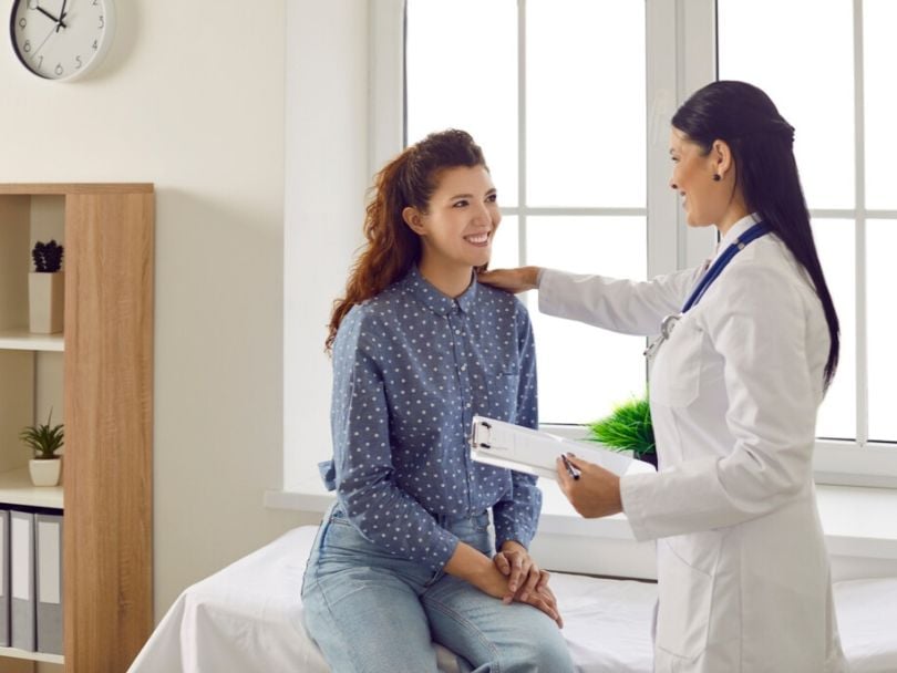 A young woman chats with her doctor in a medical office